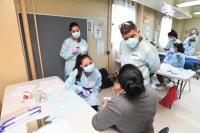 Daniel Lopez and students speak with a patient at a screening event